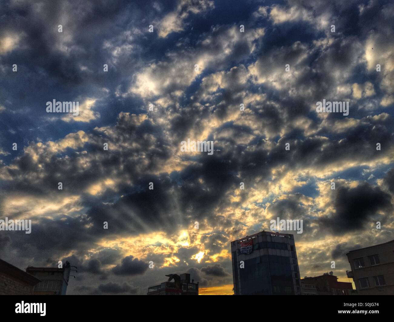 Coucher du soleil derrière les nuages avec des rayons - Place Taksim Istanbul - Turquie - Image de stock capturée avec un smartphone
