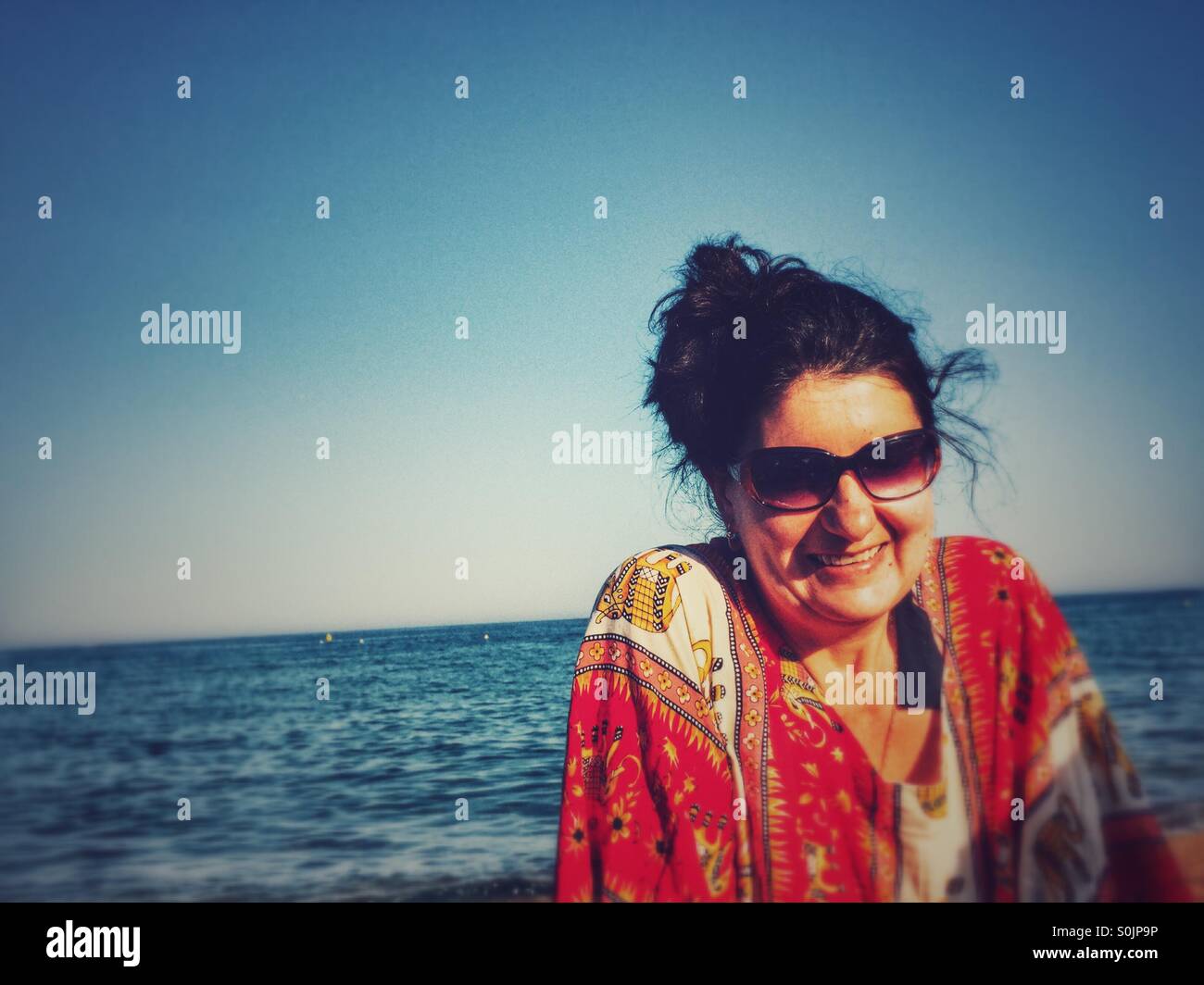Woman with sunglasses smiling sur la plage Banque D'Images Woman with sunglasses smiling sur la plage Banque D'Images