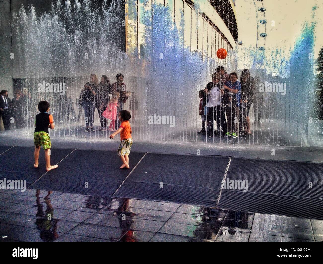 Enfants jouant dans la fontaine à l'extérieur du Royal Festival Hall au Southbank centre de Londres UK Banque D'Images