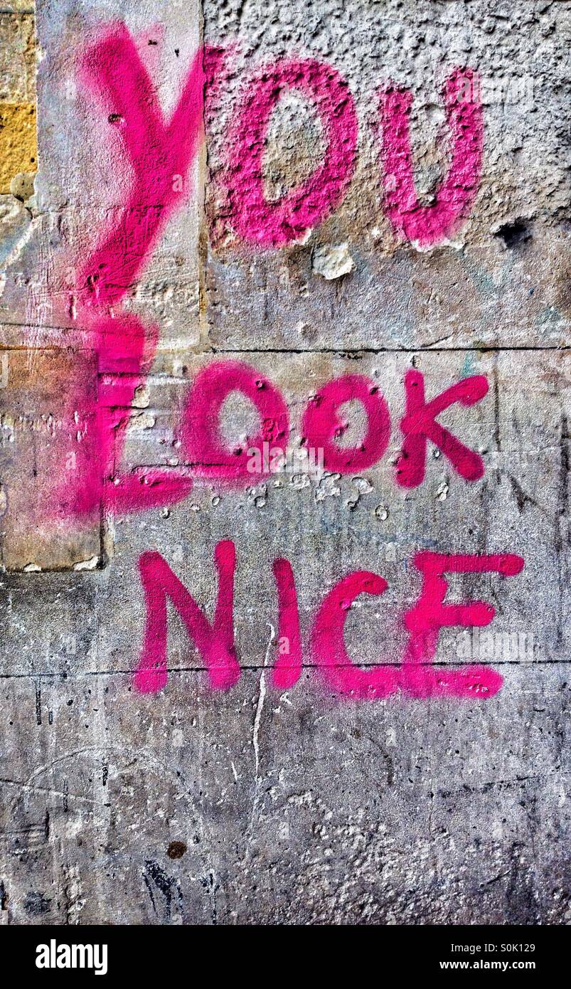 Vous regardez 'NICE' vaporisé sur un mur en peinture rose Banque D'Images