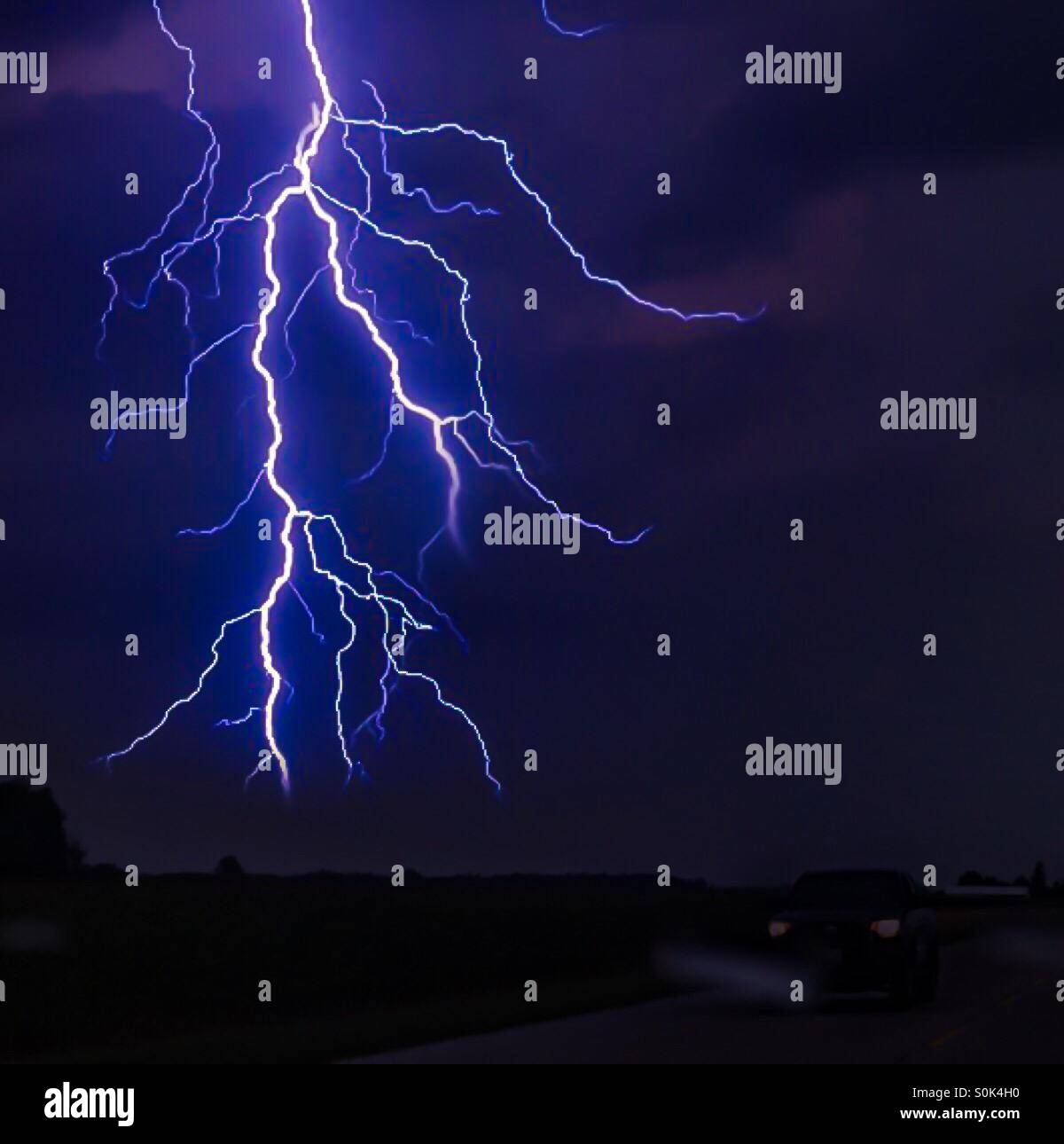 Une nuit de tempête. Un puissant éclair, avec de nombreuses stries ramifiées, éclaire un ciel sombre. Concepts : la crainte, l'étonnement, la puissance, la nature. - Image de stock capturée avec un smartphone