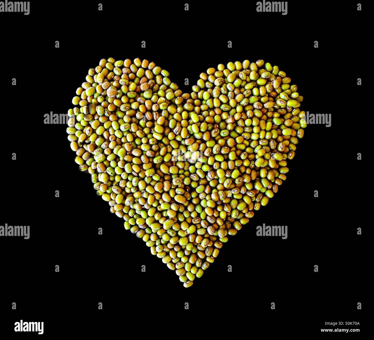 Forme de coeur avec des haricots mungo vert Banque D'Images