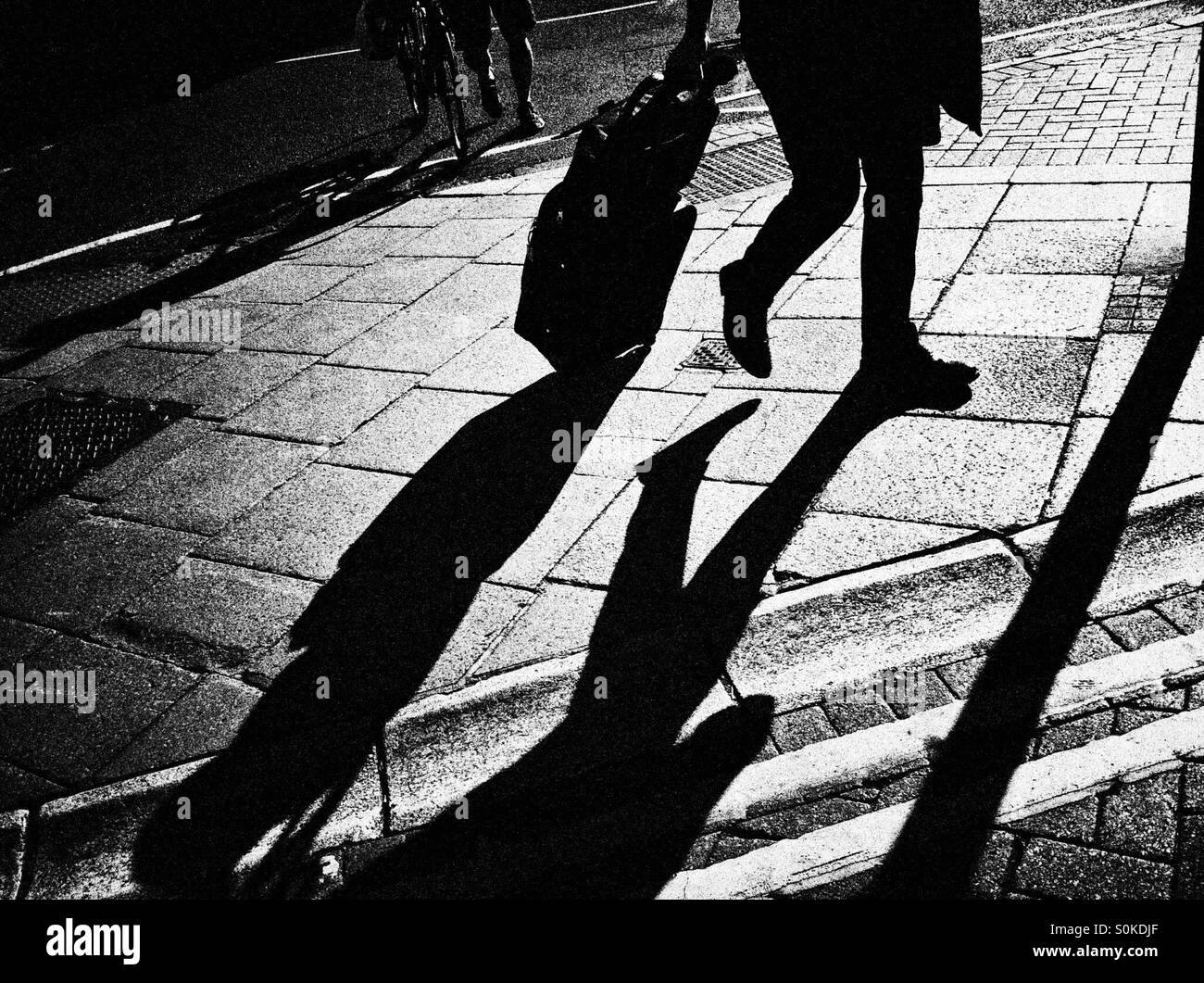 Silhouette of man wheeling bag Banque D'Images