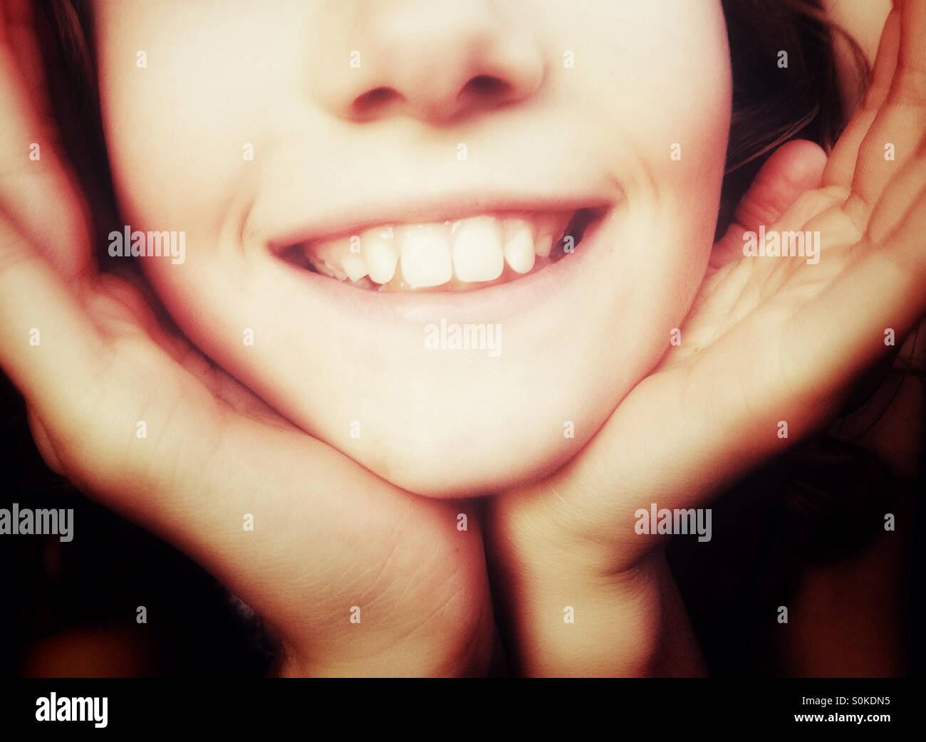 Close up of smiling woman wearing prit dans ses mains Banque D'Images