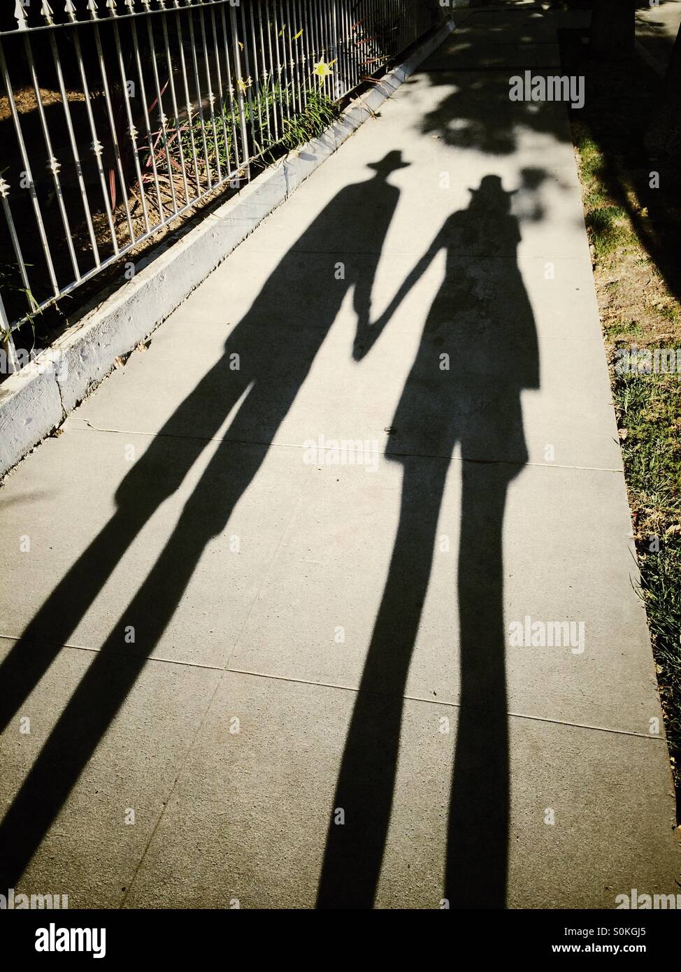 Les ombres d'un homme et une femme portant des shorts et des chapeaux Banque D'Images