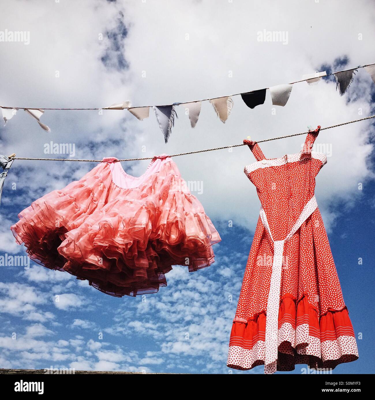 Robe rose et jupe tutu, en train de sécher dehors sur un lave-ligne. Banque D'Images