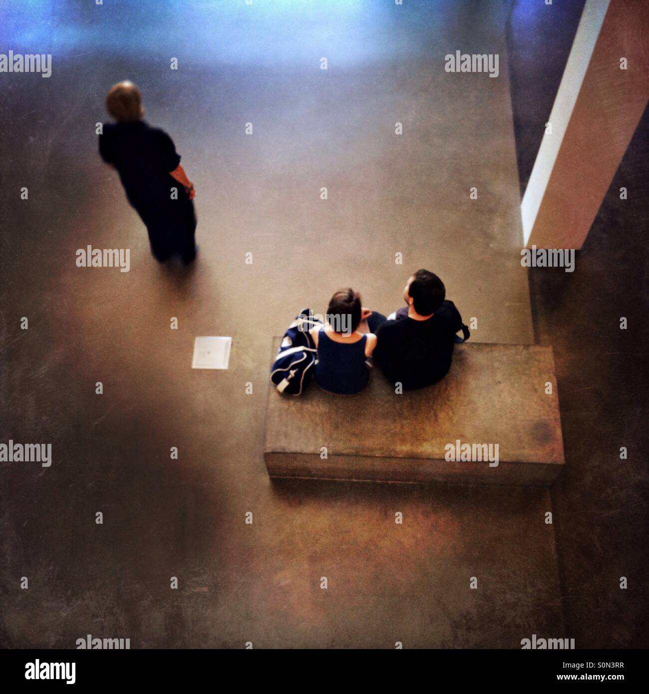 Couple avec parent tenait à proximité dans un bâtiment moderne de l'intérieur stark - Image de stock capturée avec un smartphone
