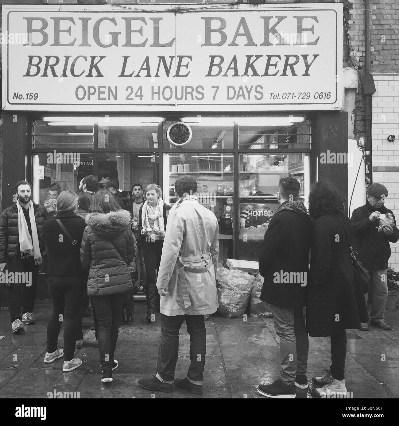 Les gens en face d'attente Beigel Bake shop, London, UK Banque D'Images