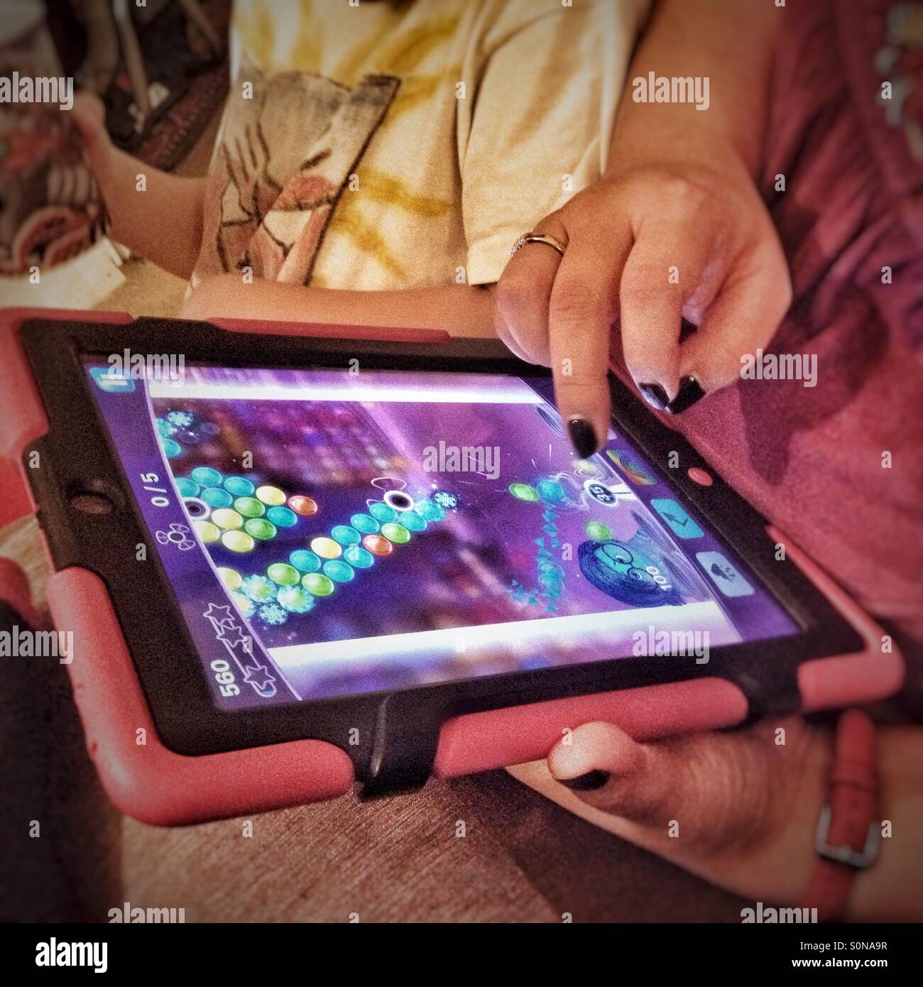 Femme jouant un jeu sur un iPad. - Image de stock capturée avec un smartphone