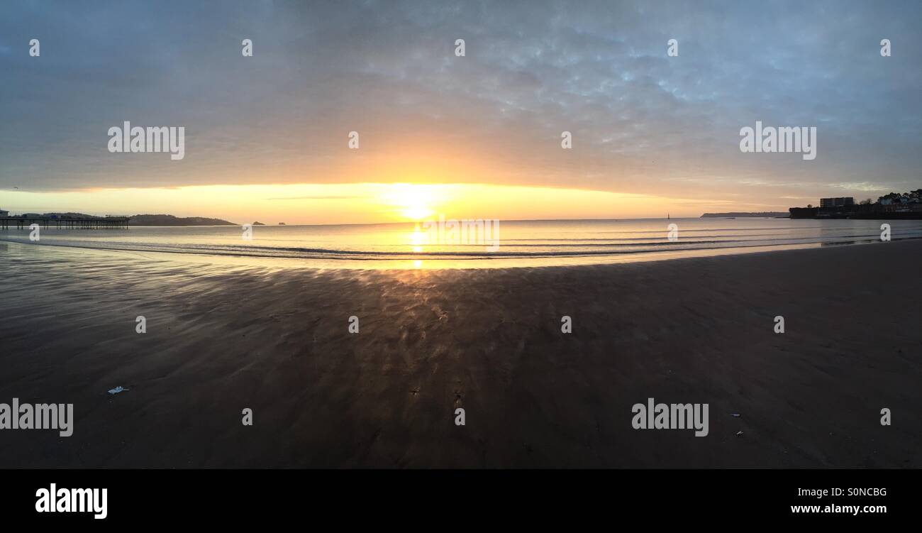Le lever du soleil sur la plage de Paignton Banque D'Images