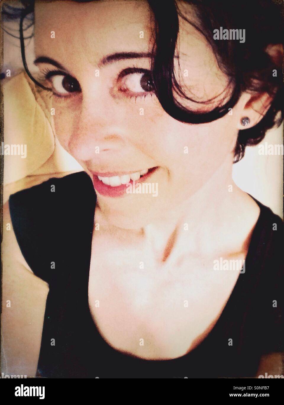 Femme avec des yeux brun foncé et les cheveux smiling - Image de stock capturée avec un smartphone