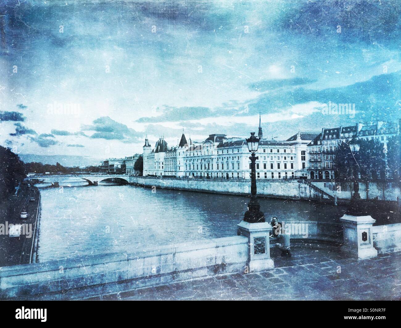 Vue de la Conciergerie sur l'Ile de la Cité à partir de l'ensemble de Seine sur le quai du Louvre. Hiver glacial d'inspiration vintage, la texture du papier calque. Banque D'Images