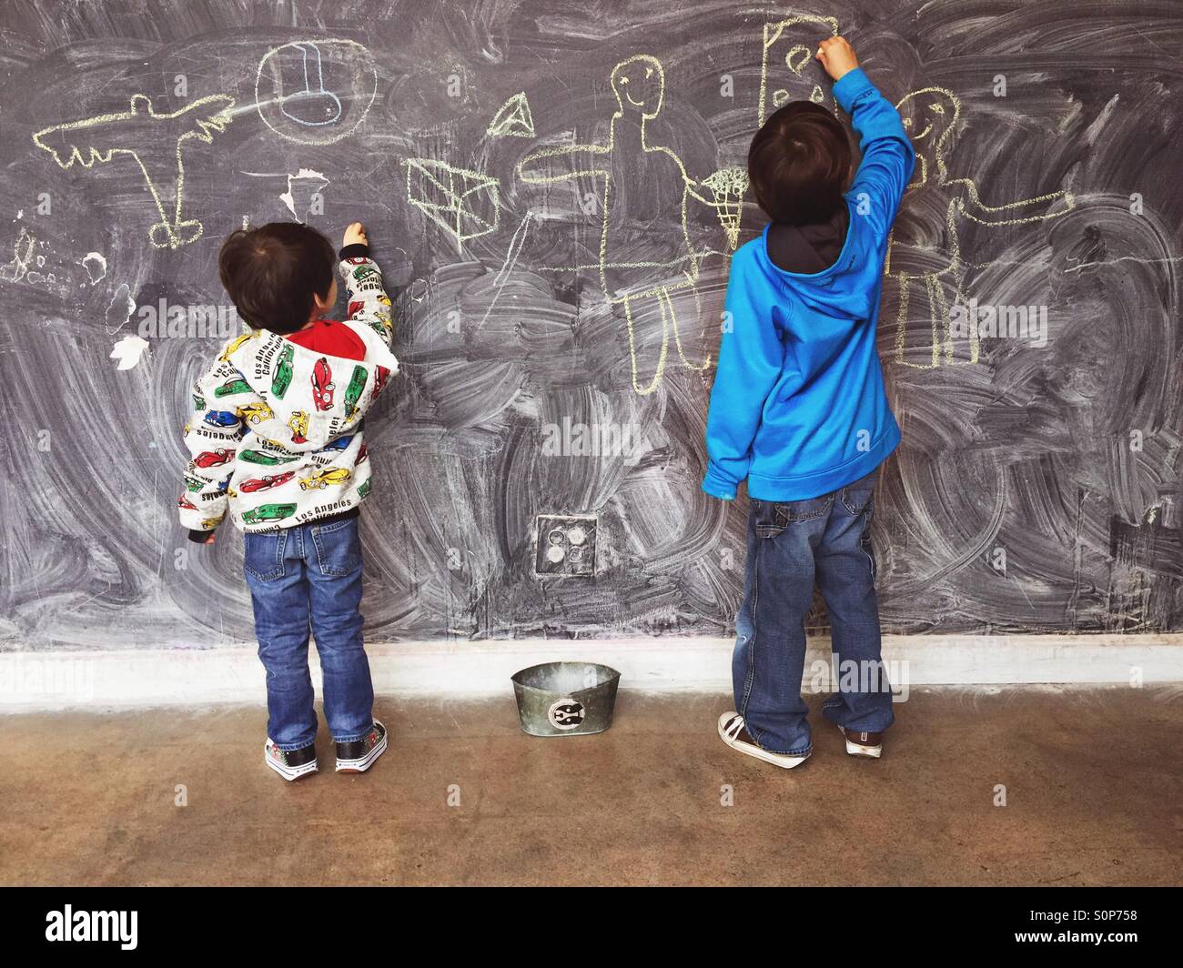 Les garçons écrit on chalkboard Banque D'Images