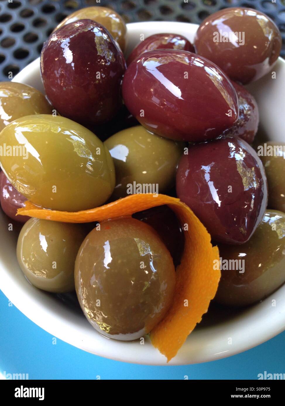 Les olives dans un bol avec le zeste d'orange Banque D'Images