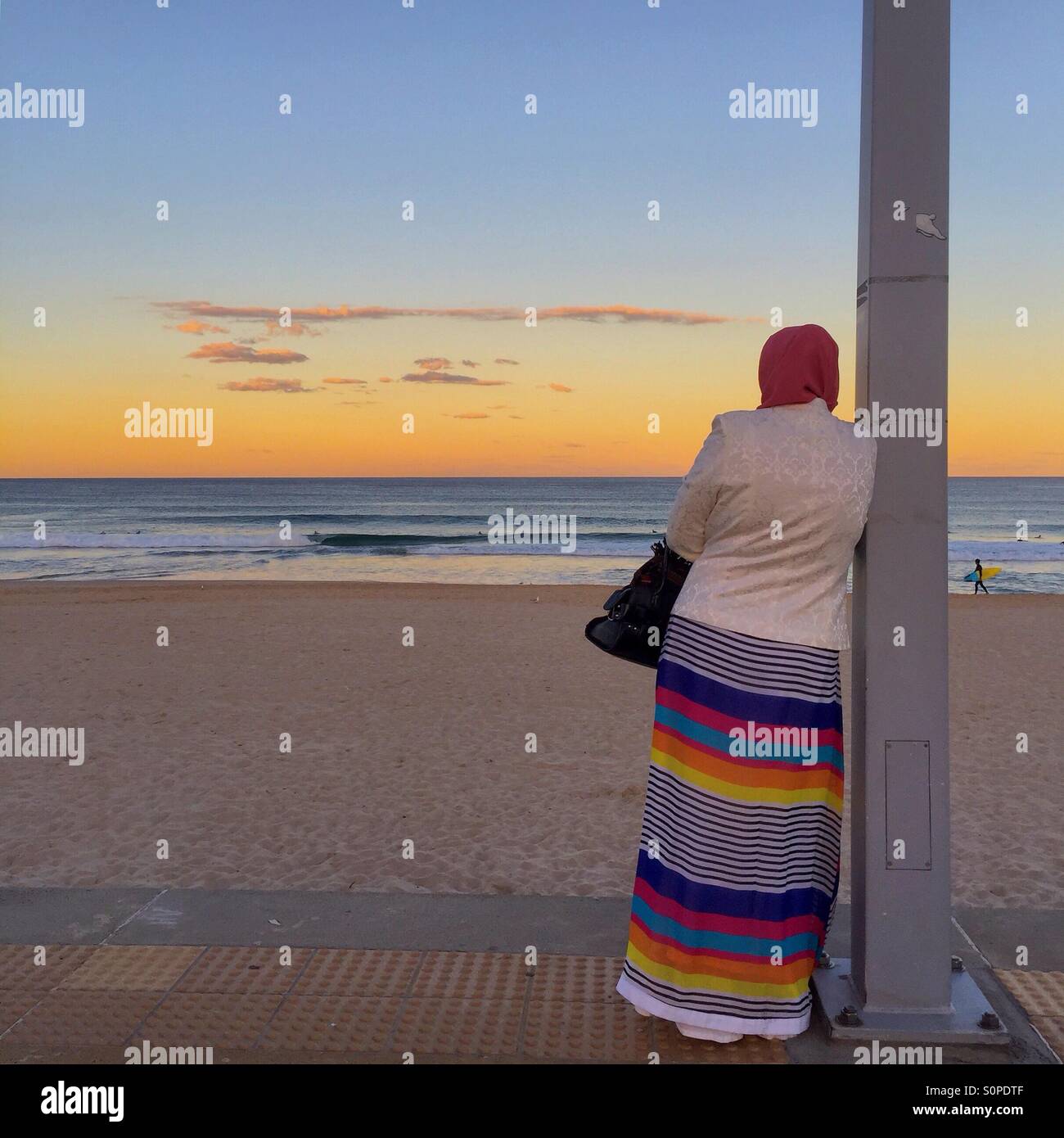 Femme musulmane dans des vêtements colorés avec sa ocean sunset Banque D'Images