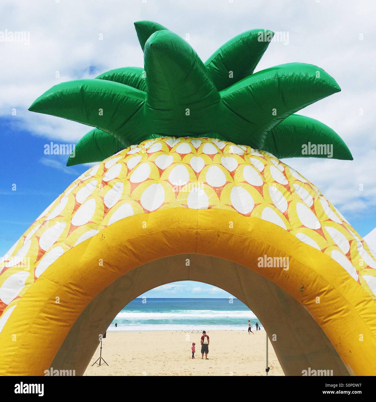 L'ananas géant flottait sur la plage avec une vue sur l'océan Banque D'Images