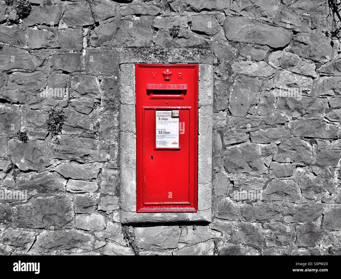 A Victorian post box set dans un mur de pierre sur une rue de ville en Angleterre - Image de stock capturée avec un smartphone