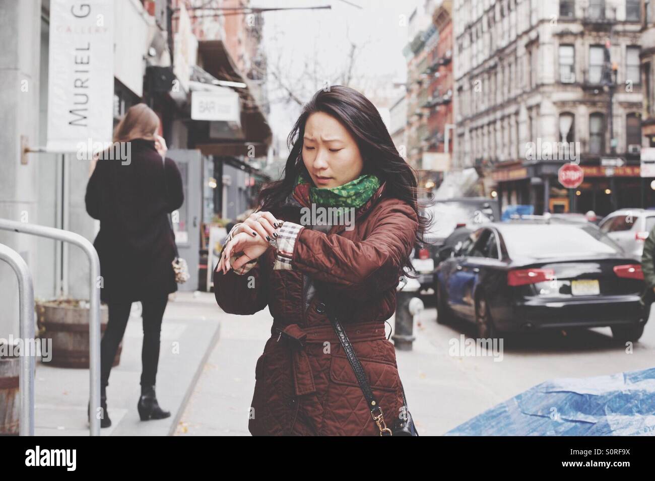 Girl vérifie sa montre sur un trottoir de Manhattan à New York, NY, USA. Banque D'Images