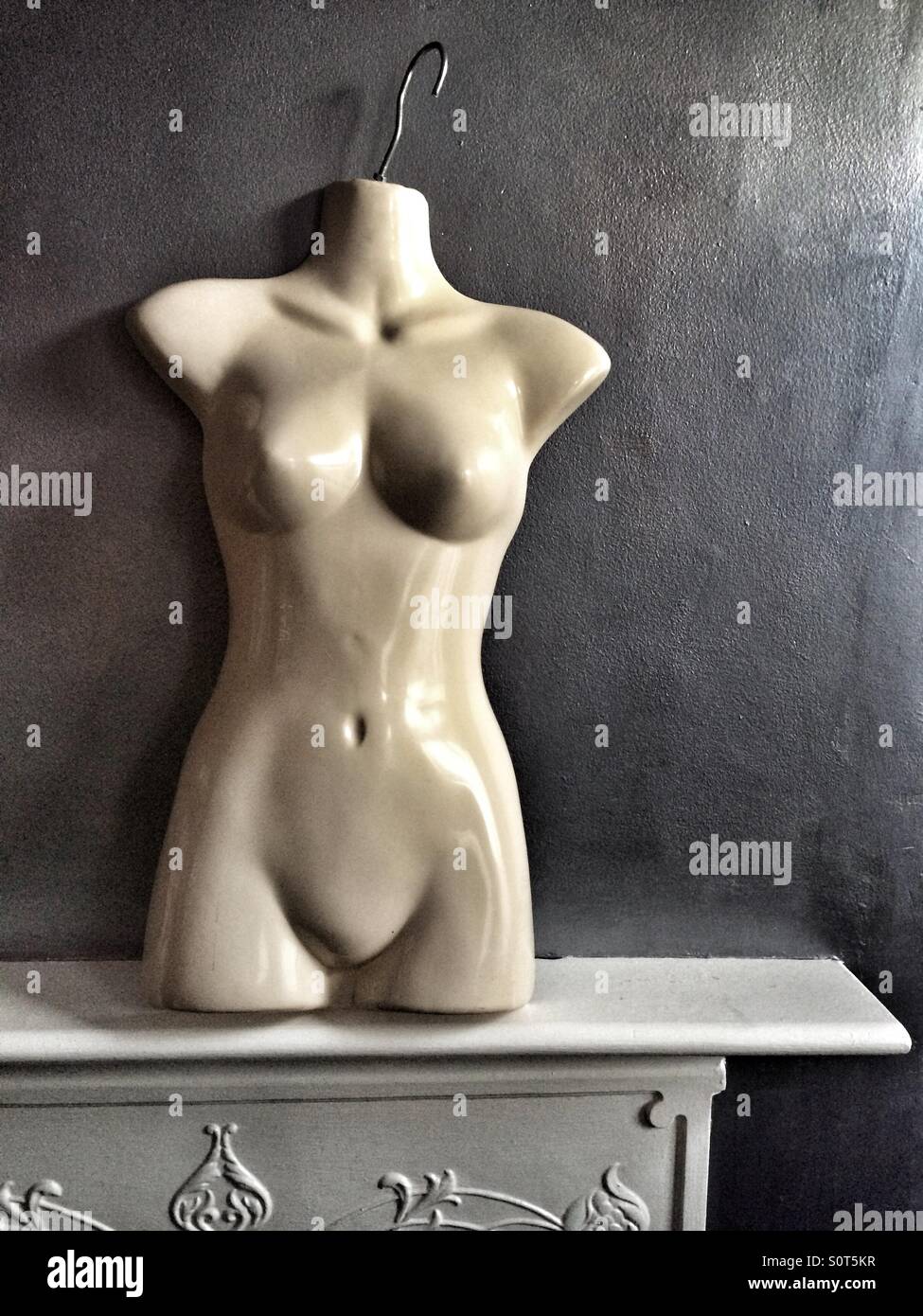 Un female mannequin debout sur une cheminée, ressemblant à une statue grecque classique - Image de stock capturée avec un smartphone Un female mannequin debout sur une cheminée, ressemblant à une statue grecque classique - Image de stock capturée avec un smartphone