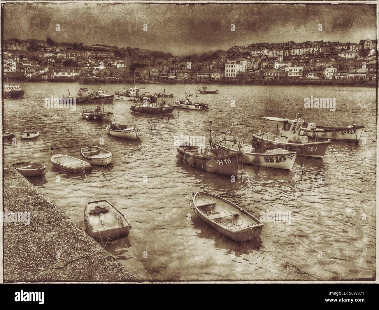 Une variété de petits bateaux dans le port de St Ives. Une photo montrant l'effet antique vue de Smeaton's Pier à travers le port en direction de la ville de Saint Ives en Cornouailles, Angleterre. Photo © Colin Hoskins Banque D'Images