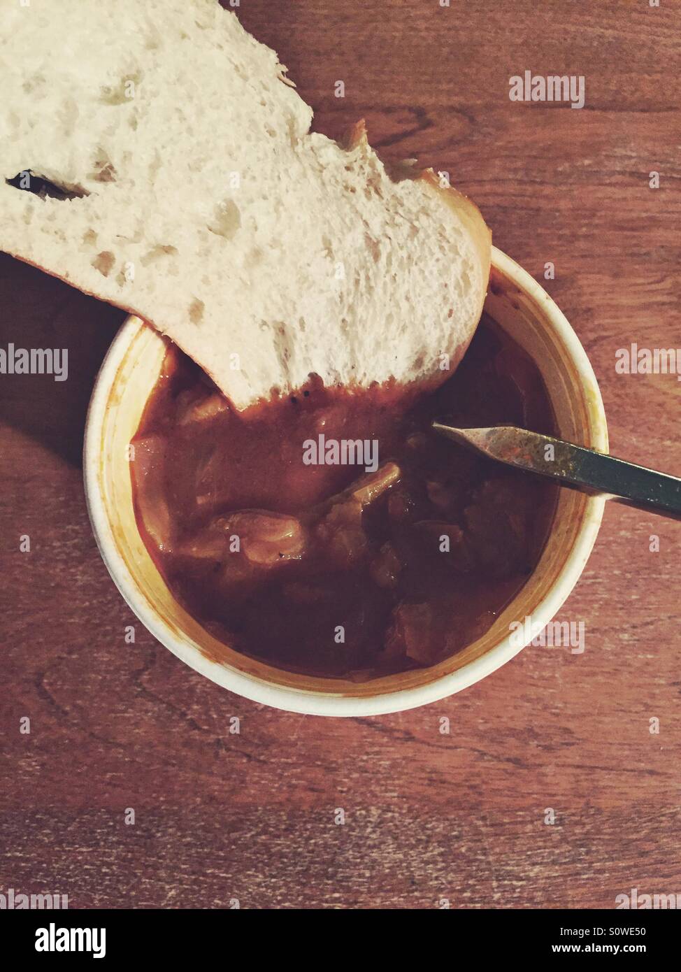 La soupe au chou aigre-doux avec du pain dans un récipient pour emporter sur une table en bois Banque D'Images
