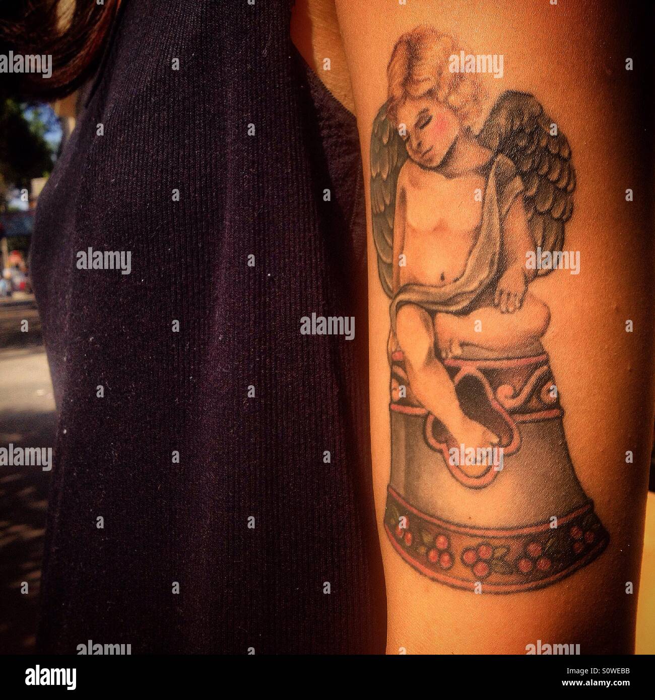 Une femme féminine montre un tatouage d'un Ange assis sur une cloche dans la Colonia Roma, Mexico, Mexique Banque D'Images