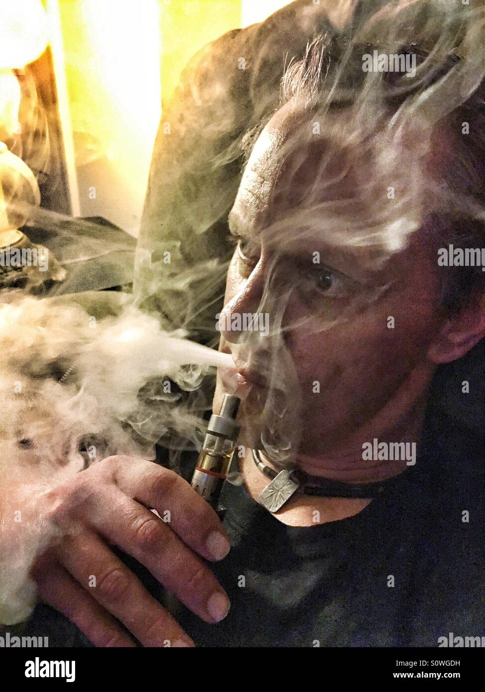L'homme à l'aide de e-cig que quelques bouffées de vapeur de fumée Banque D'Images