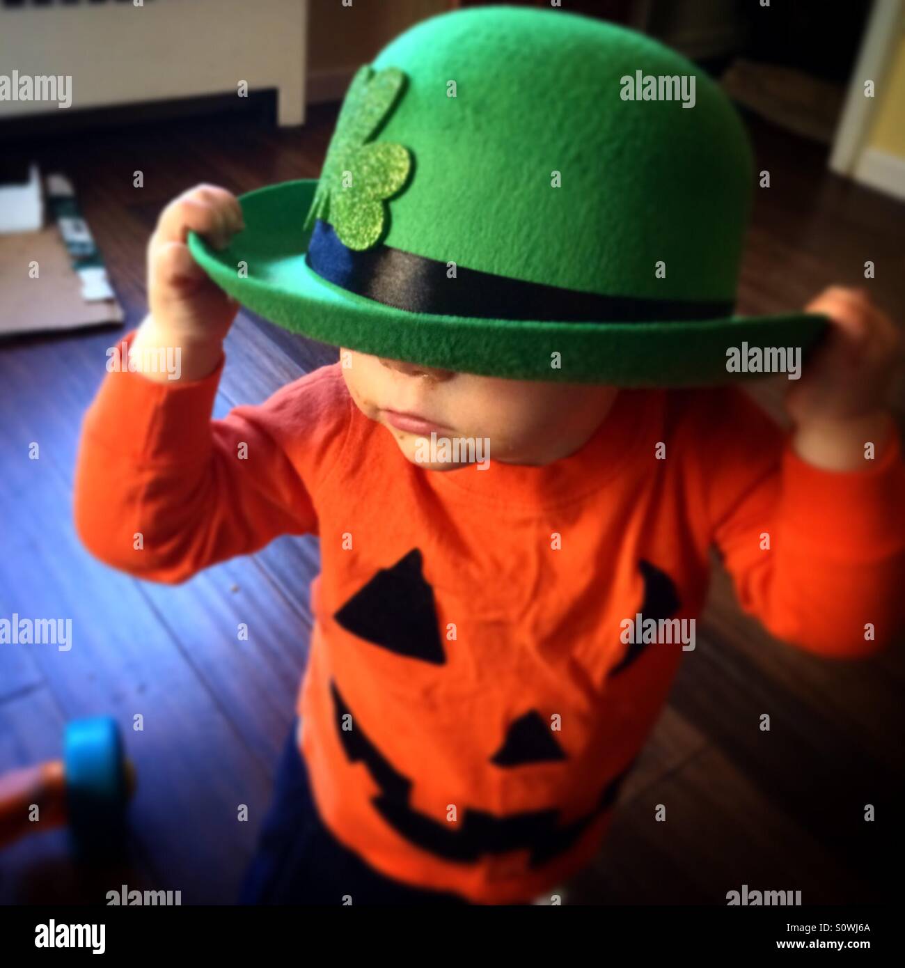 Bébé portant un chapeau et un jour saint Patrick Halloween shirt Banque D'Images