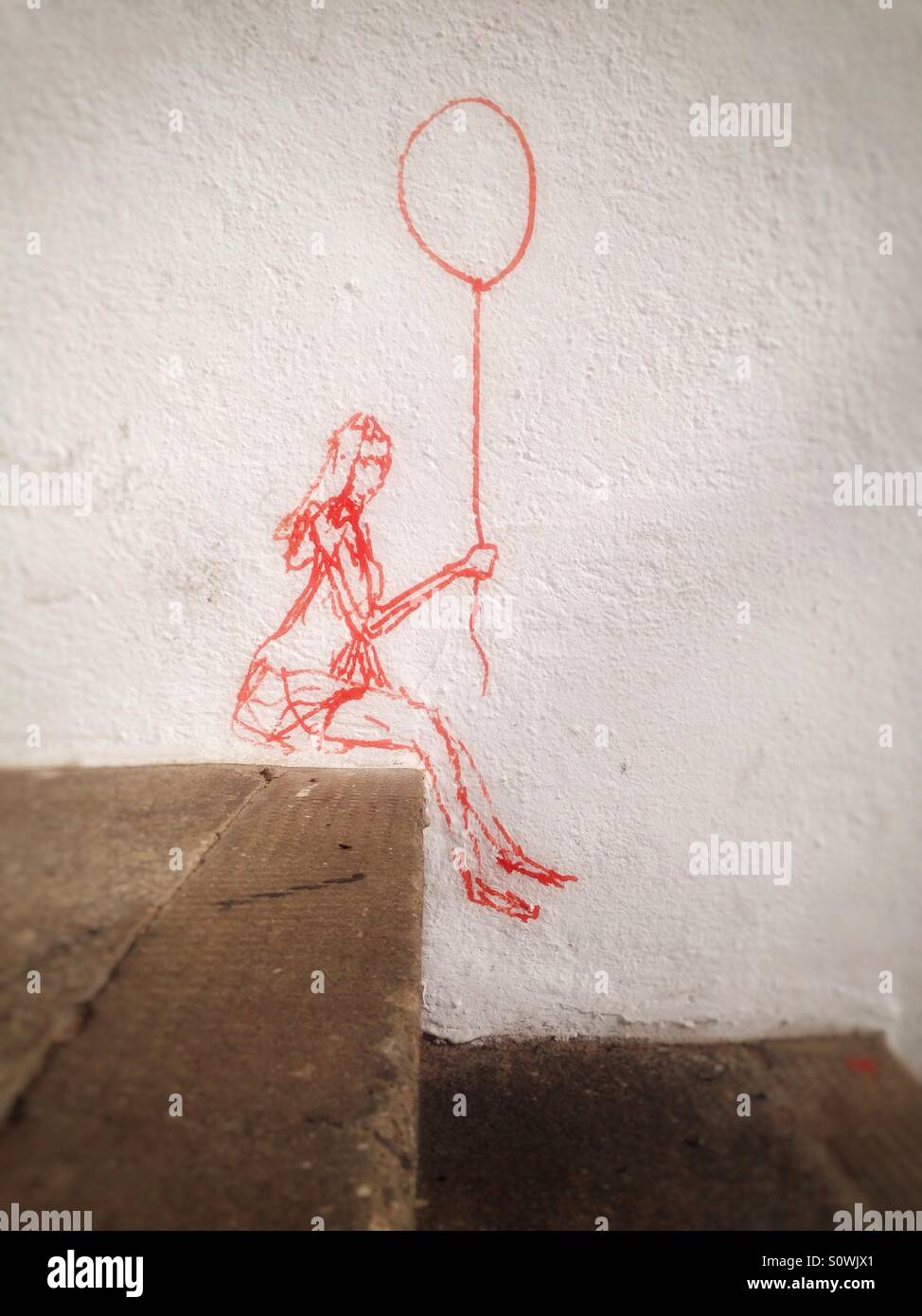 Fille assise sur un rebord avec ballon en main, le street art à Berlin, Allemagne - Image de stock capturée avec un smartphone