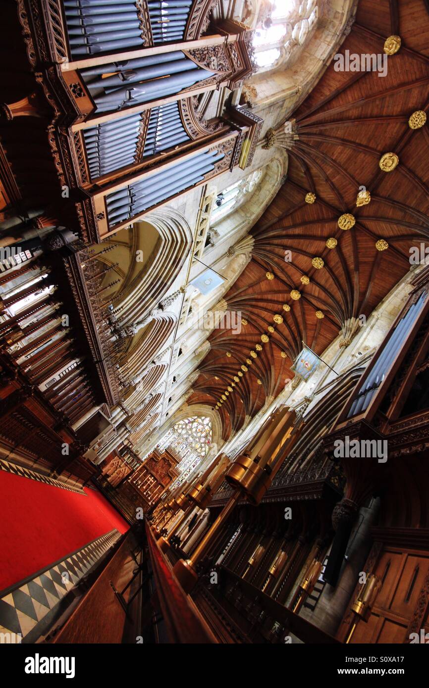 L'intérieur d'une cathédrale majestueuse avec des sculptures en bois et maçonnerie décorative. À la recherche sur le tapis rouge sur l'allée d'une grande église à un angle. Banque D'Images