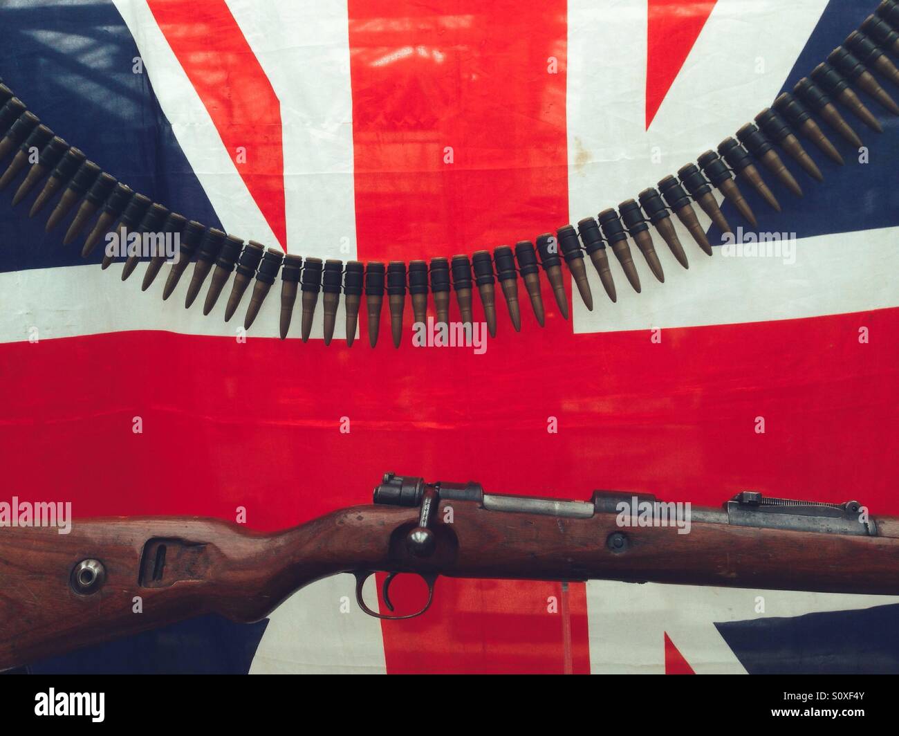 Un fusil militaire et des munitions en face d'un Union Jack Banque D'Images