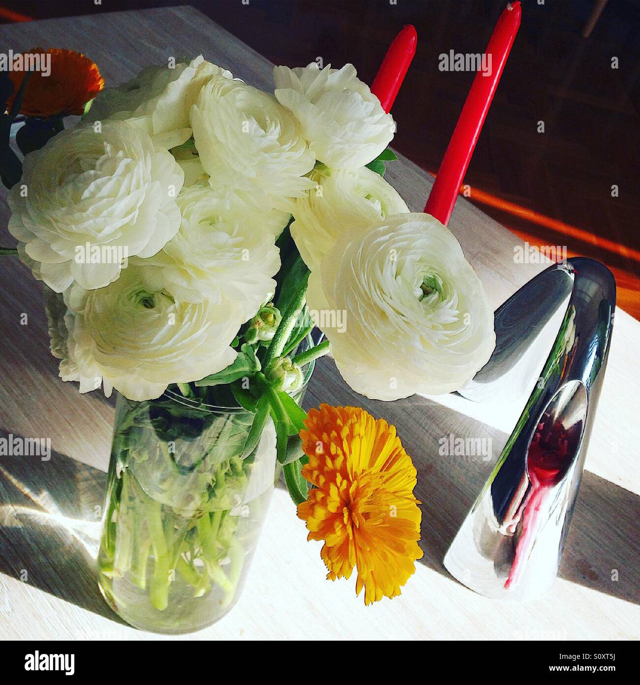 Fleurs blanches dans un vase en verre sur une table en bois blanc. Banque D'Images