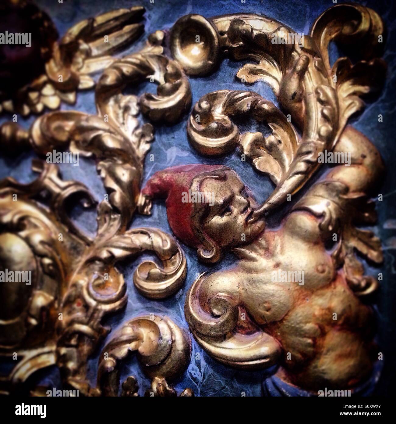 Une sculpture en bois doré d'un mithological créature portant un chapeau rouge et soufflant une corne décore la cathédrale de Santa Maria à Astorga, Maragateria, Espagne Banque D'Images