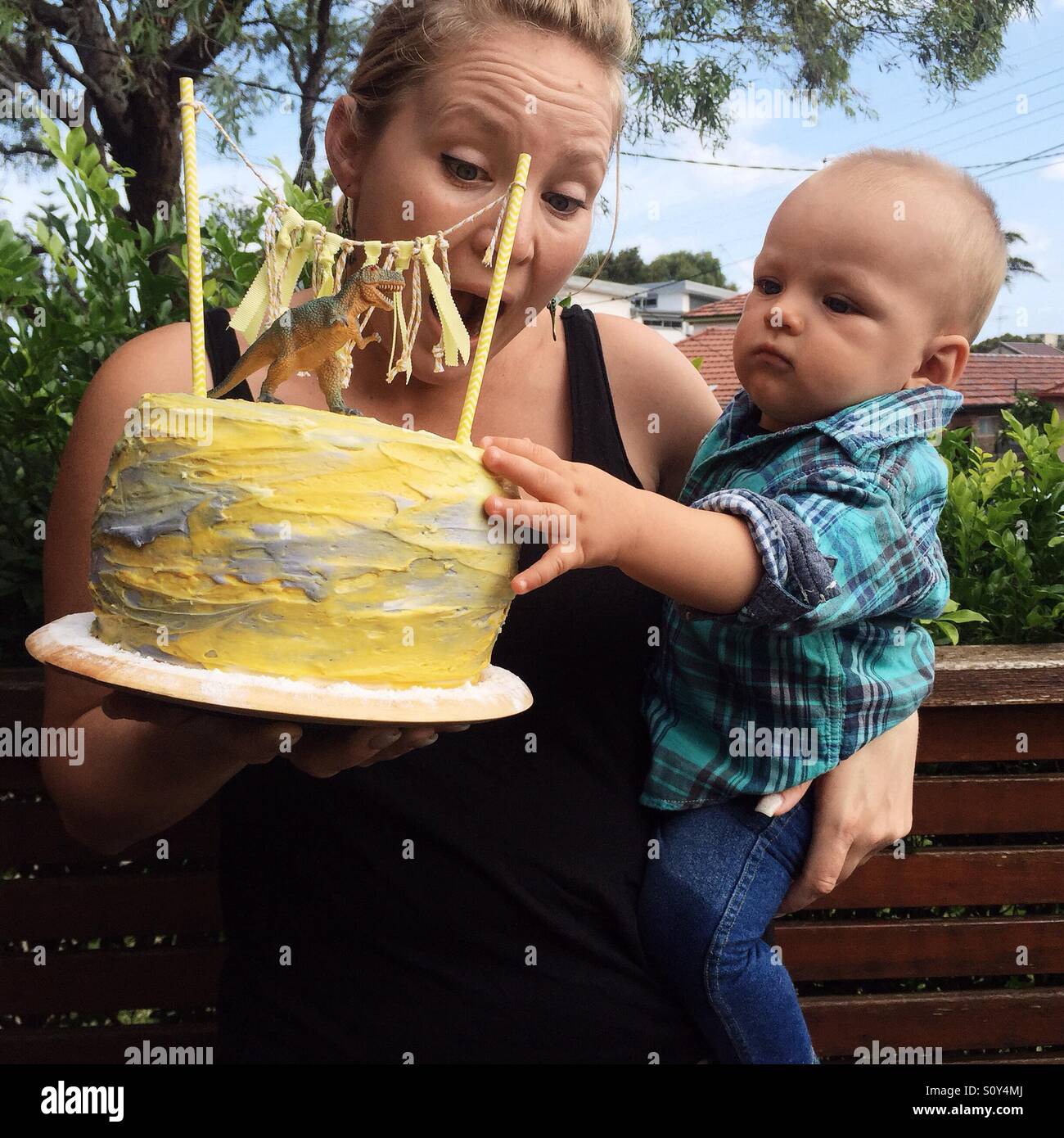 Petit enfant de toucher le gâteau d'anniversaire Banque D'Images