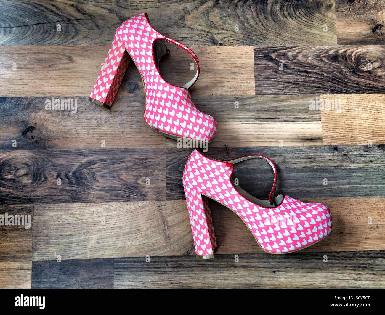 Une paire de chaussures à talon pour femmes avec un intervalle de répétition des coeurs, sur un sol en bois Banque D'Images