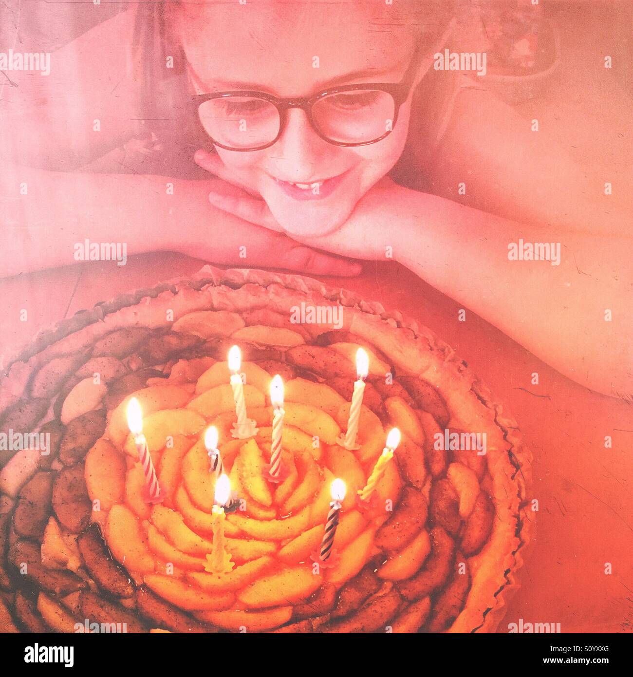 Petite fille avec des lunettes à son anniversaire à tarte aux 8 BOUGIES Banque D'Images