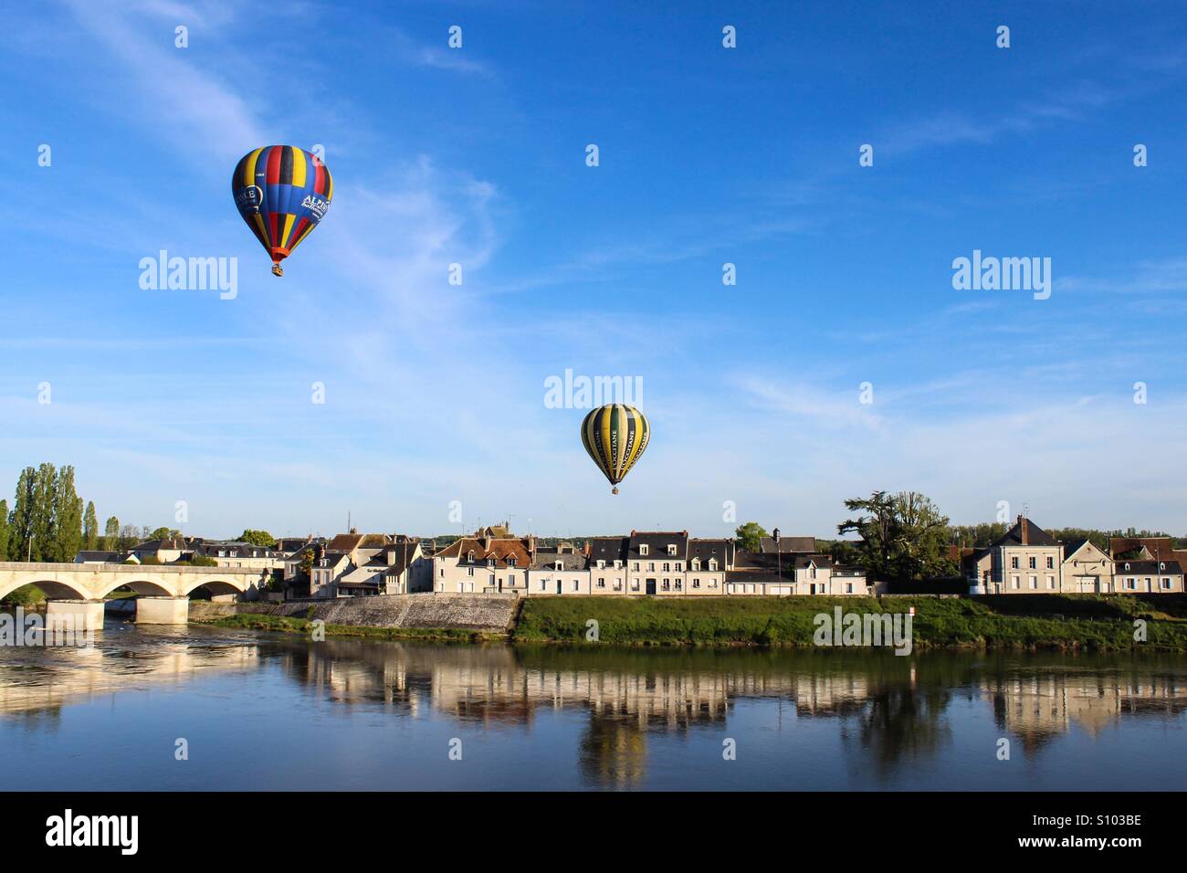Montgolfières survolant la rivière sur un beau jour Banque D'Images