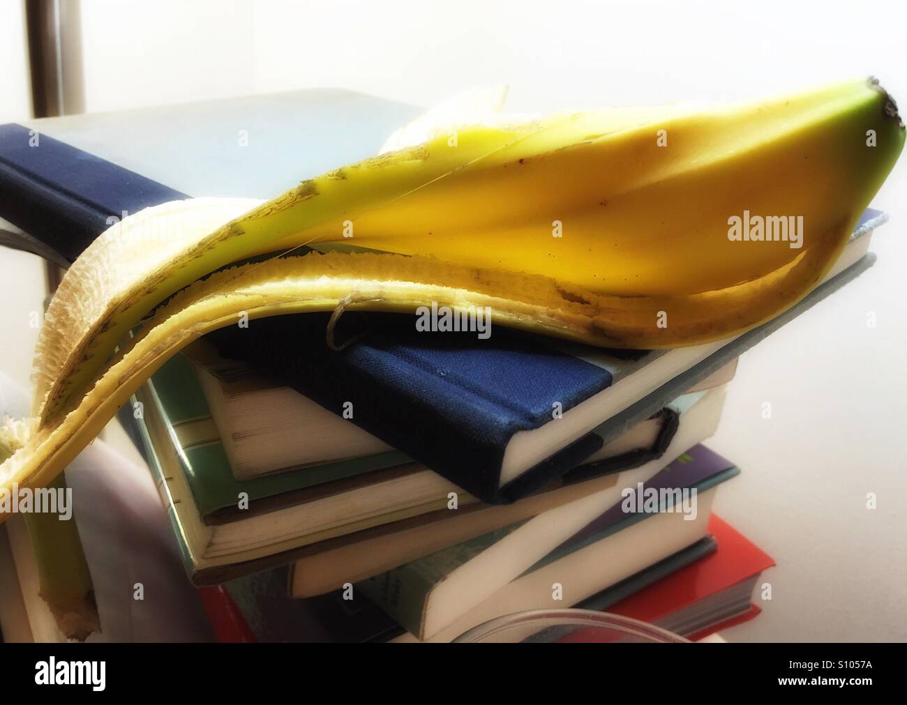 Peau de banane sur la pile de livre Banque D'Images