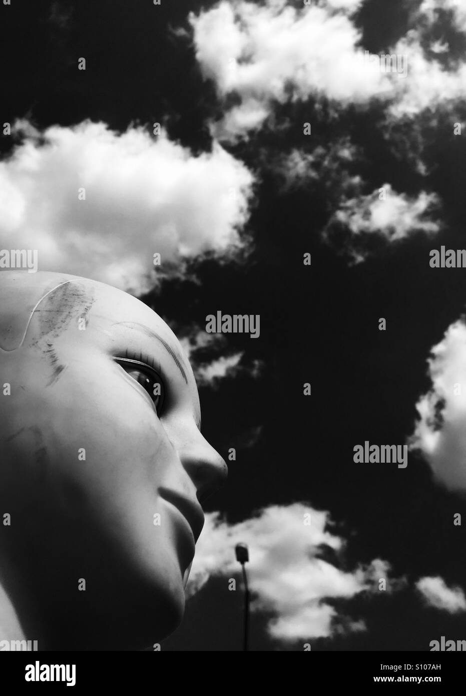 Female mannequin head avec des nuages et du ciel en noir et blanc Banque D'Images