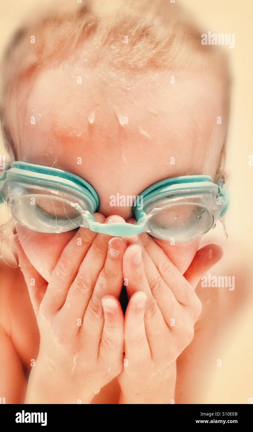 Jeune fille portant des lunettes et essuyant ses yeux après la baignade Banque D'Images
