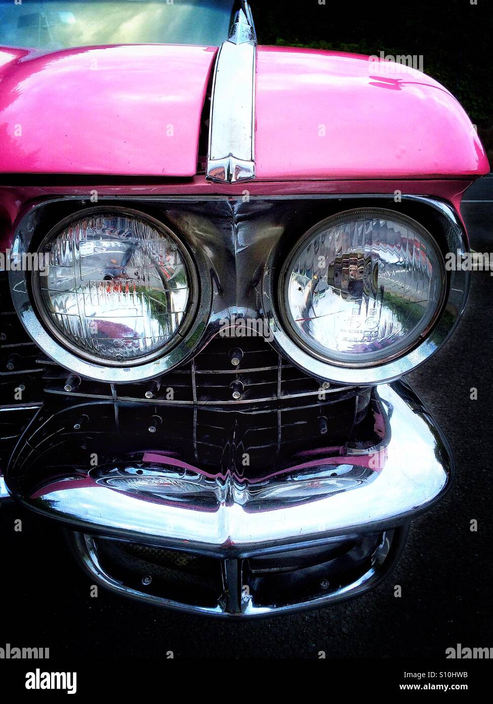 Phares sur une Cadillac rose à l'image d'un visage Banque D'Images