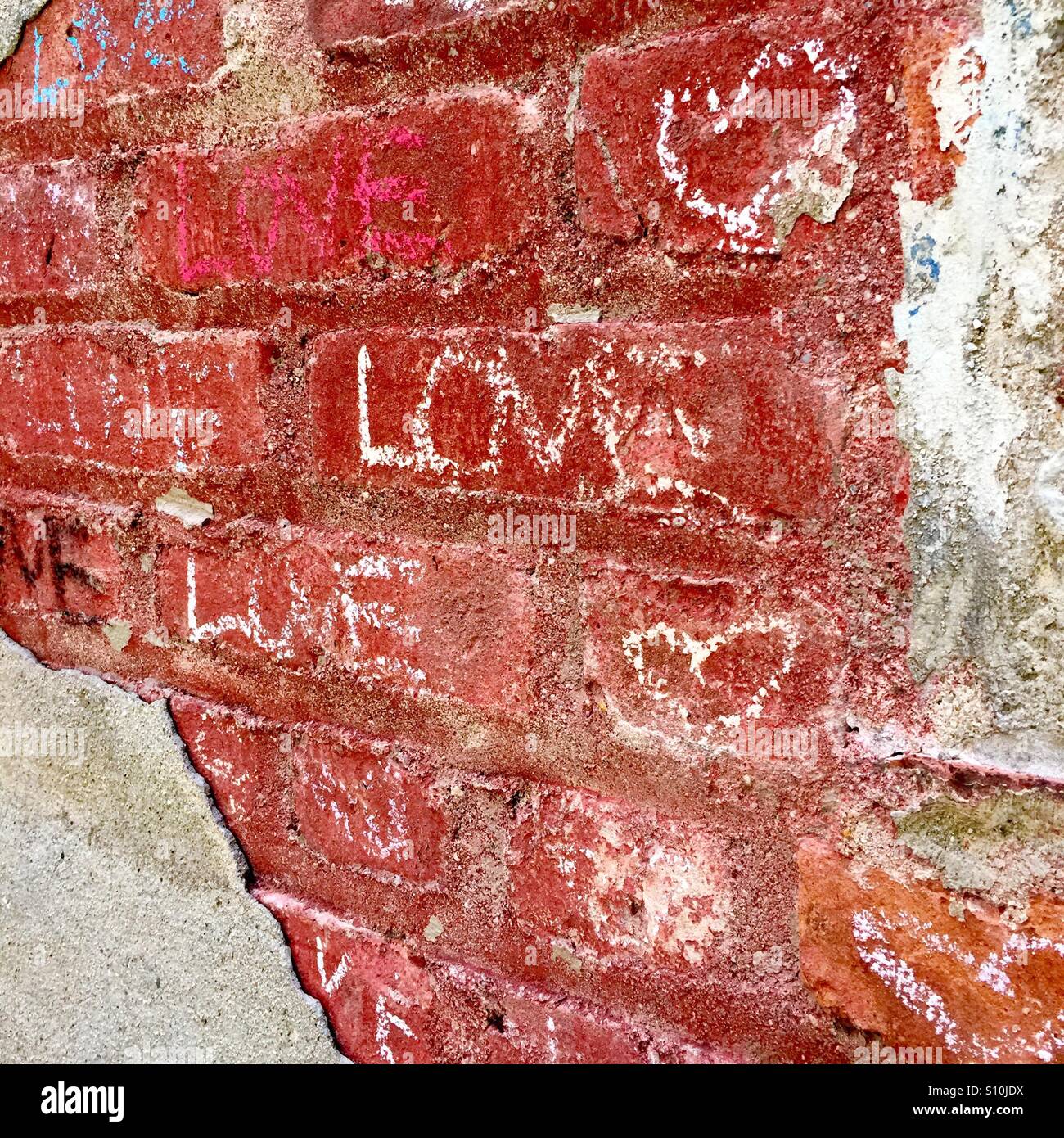 L'amour à la craie sur Graffiti brique rouge Banque D'Images