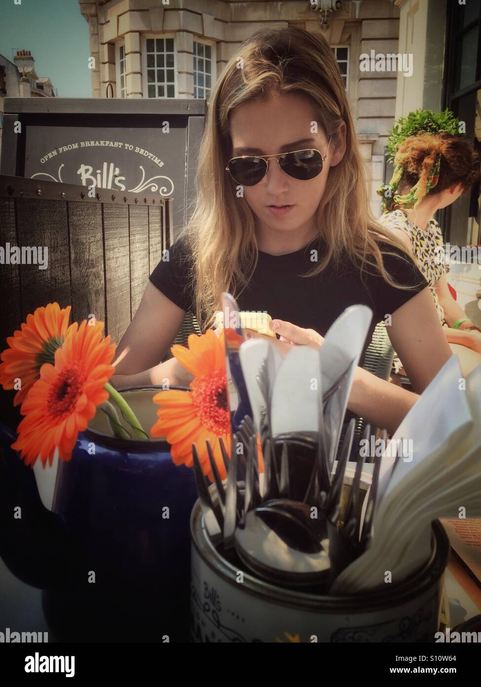 Femme manger à l'extérieur avec un téléphone mobile dans le soleil - Image de stock capturée avec un smartphone