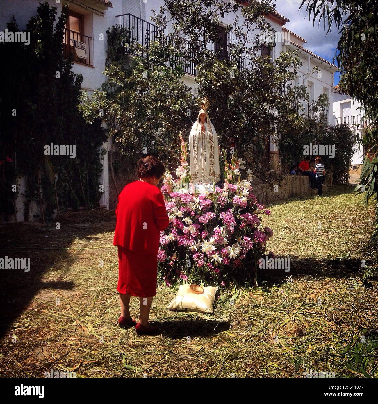 Une femme vêtu de rouge prie Notre Dame de Fatima au cours de Corpus Christi à El Gastor, Sierra de Cadiz, Andalousie, Espagne Banque D'Images