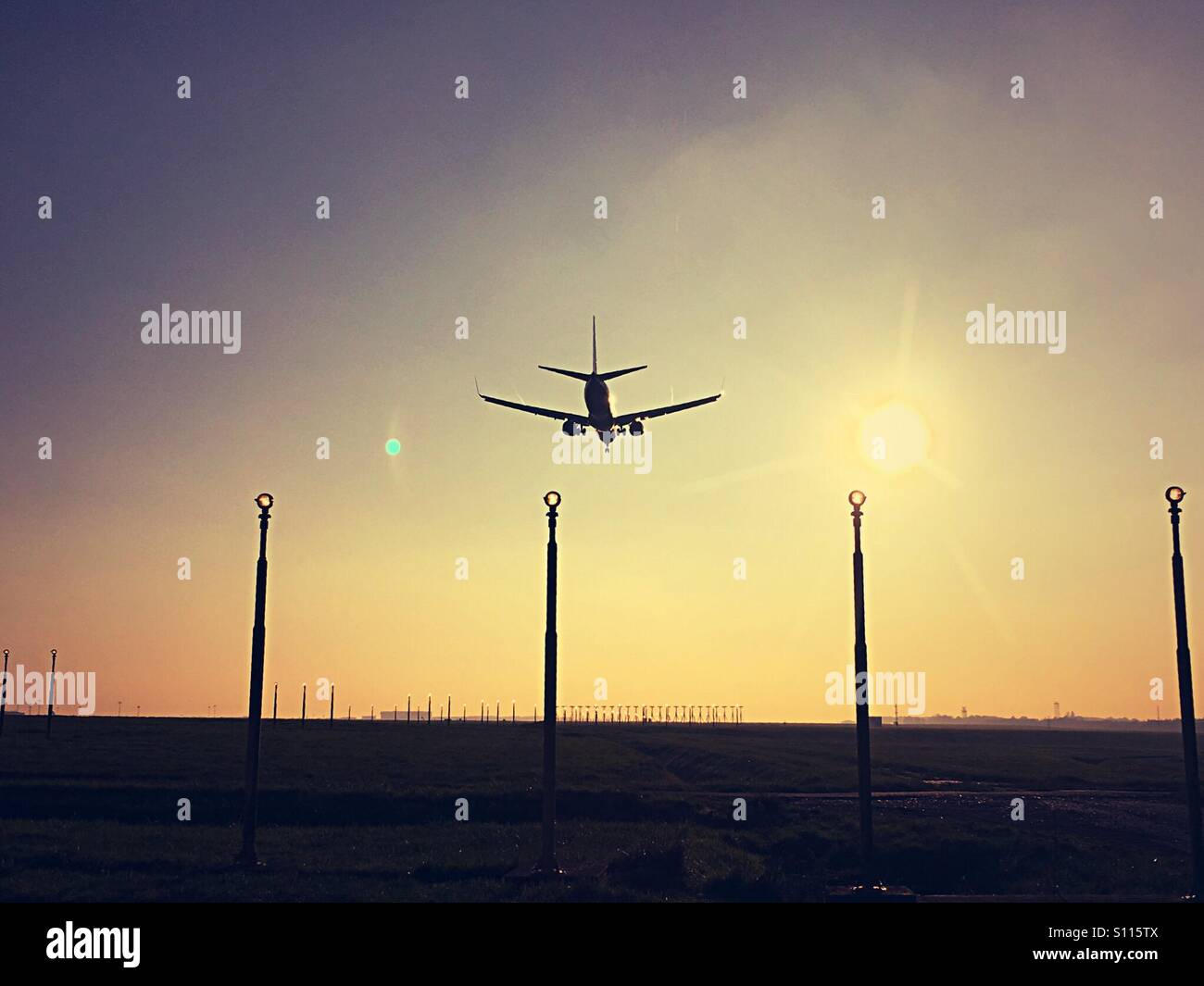 Avion qui m'en terre au coucher du soleil Banque D'Images