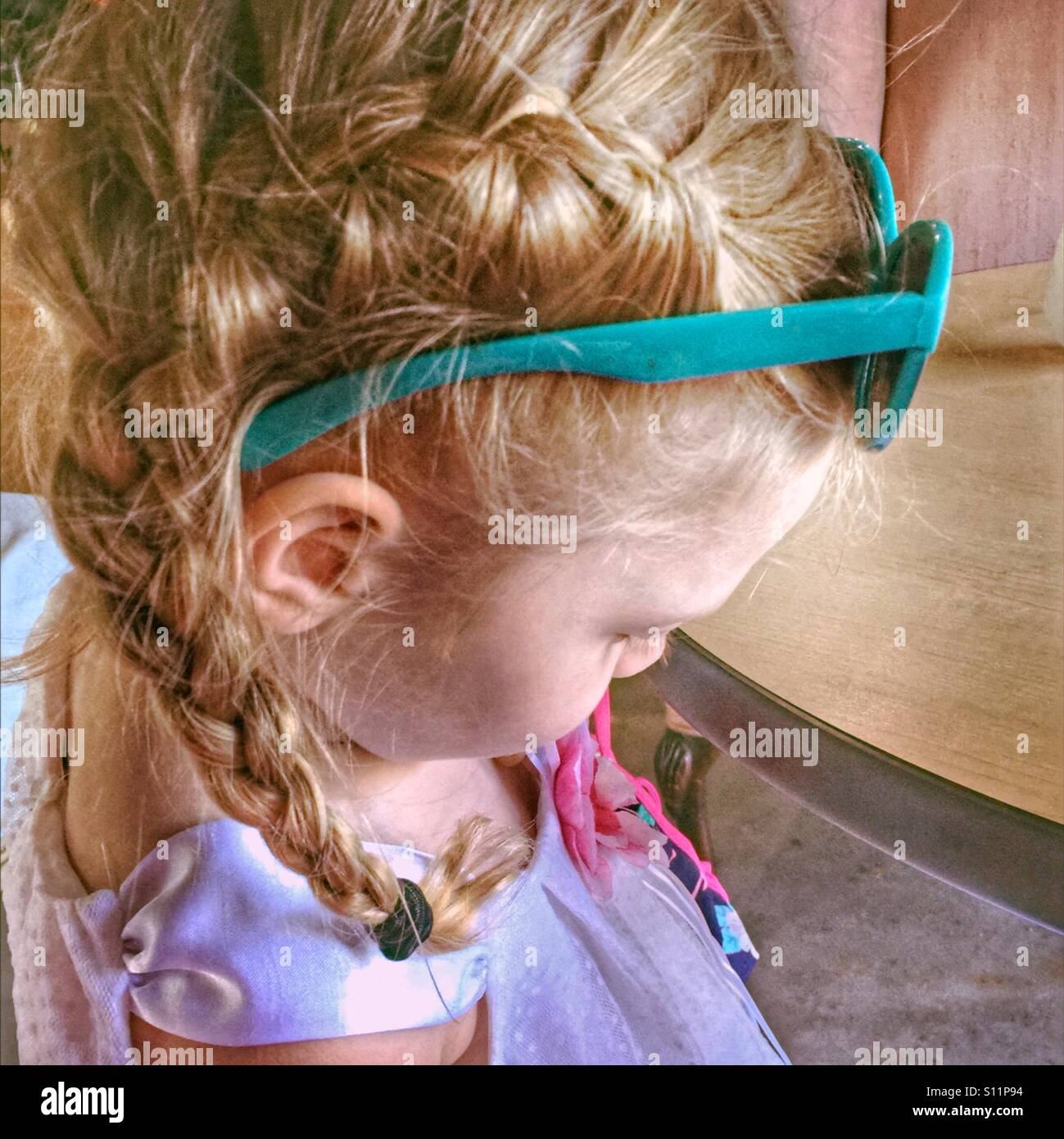 Vue latérale d'une petite fille en français portant des lunettes de queues de cochon tresse sur la tête. Banque D'Images