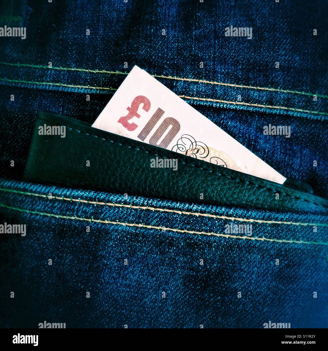 Une poche du pantalon avec un porte-monnaie et une note de dix livres Banque D'Images
