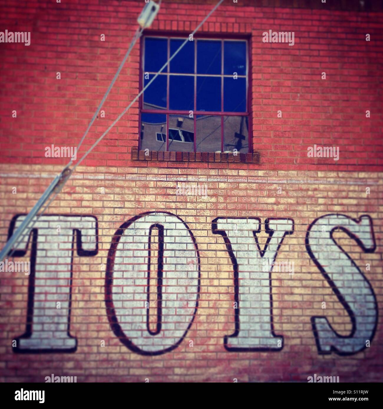Panneau de JOUETS en briques peintes sur un mur de magasin de jouets sur Solano Avenue à Berkeley, en Californie. - Image de stock capturée avec un smartphone