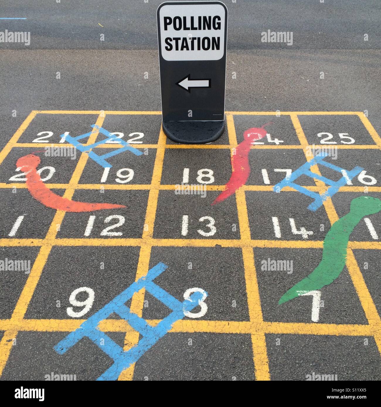 Un bureau de scrutin signe sur un conseil de serpents et échelles Banque D'Images