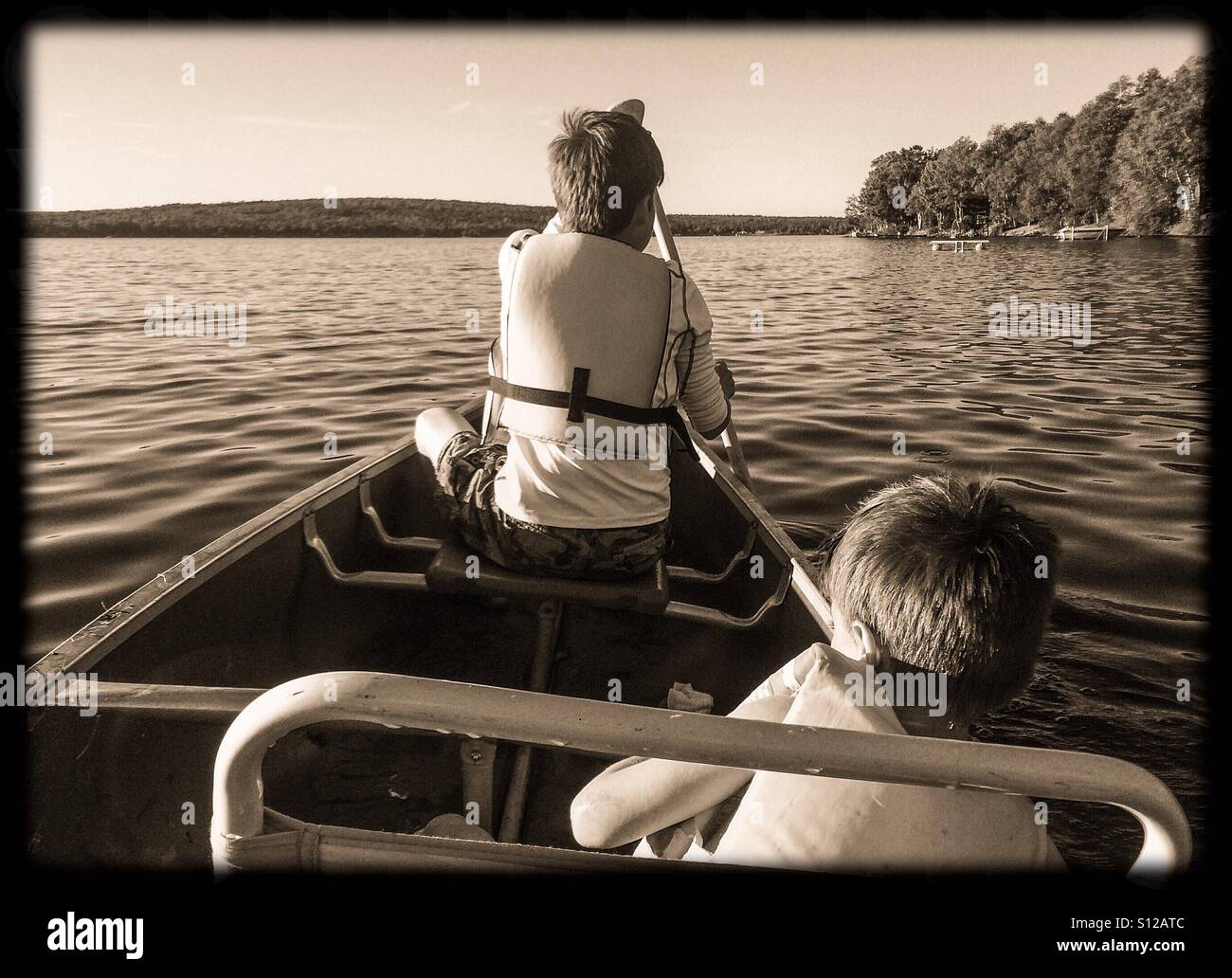 Deux frères en canoë sur un lac, dans le nord du Maine. Banque D'Images